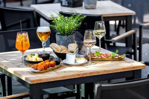 a wooden table with food and glasses of wine at Broeck Oudewater in Oudewater