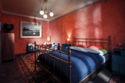 a bedroom with a bed in a red wall at Apartmány Za branou in Kutná Hora
