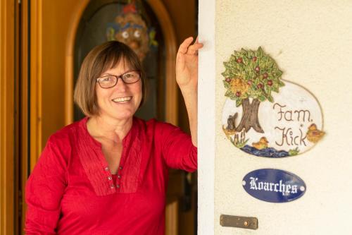 a woman standing next to a wall with a tree on it at Ferienwohnung Haus Inge in Moosbach