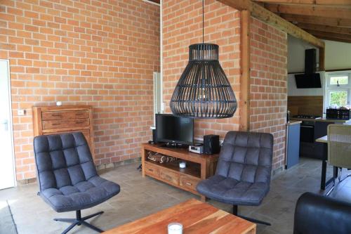 a living room with two chairs and a television at Rekerlanden 98 in Schoorldam