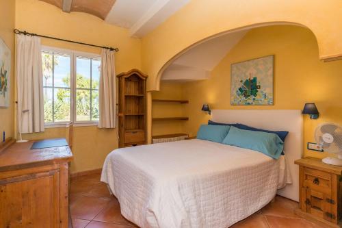 - une chambre avec un grand lit et une fenêtre dans l'établissement Villa Estrellita Sant Lluis, à Sant Lluis