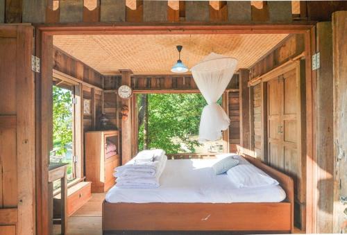 a bed in the middle of a room with a window at 467 Chiang Dao in Chiang Dao