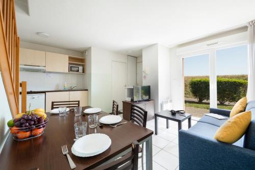 une cuisine et une salle à manger avec une table et une salle à manger dans l'établissement Garden & City Clermont-Ferrand - Gerzat, à Gerzat