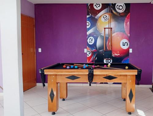 uma mesa de bilhar num quarto com um monte de bolas em Casa de temporada Guarapari Casa Dule em Guarapari