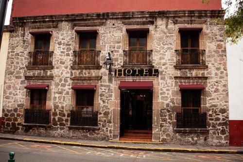 a building with a hotel sign on the side of it at Hotel el Carmen in Morelia