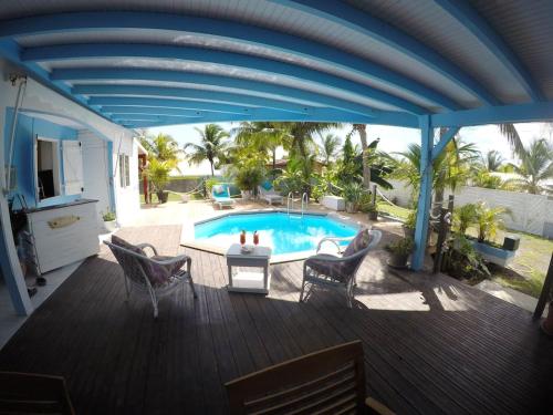 a deck with a pool and a table and chairs at Villa ensoleillée avec piscine privée à Saint-François in Saint-François