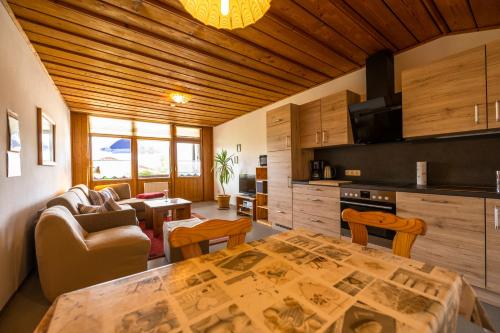 a kitchen and living room with a table in a room at Ferienwohnung Haus Inge in Moosbach