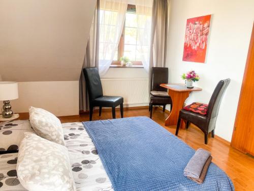 1 dormitorio con cama, sillas y mesa en Emilio, en Kudowa-Zdrój