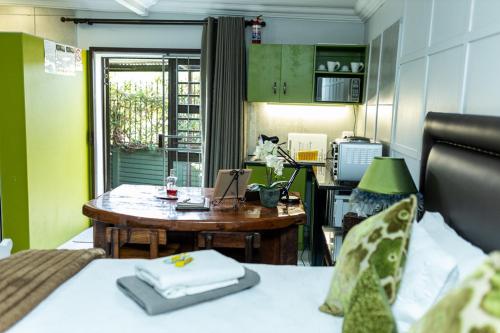 a room with a desk and a bed and a table at Rustic Forest Guest House in Cerillio