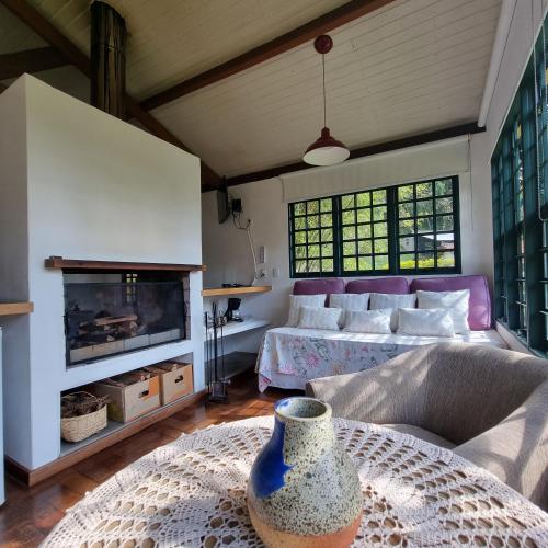 a living room with a bed and a fireplace at Pousada da Mata in Cunha