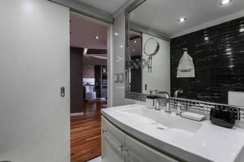 bagno con lavandino e specchio di HOUSE LORCA a Buenos Aires