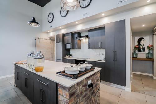 a kitchen with black cabinets and a counter top at The Greens Guest House in Knysna