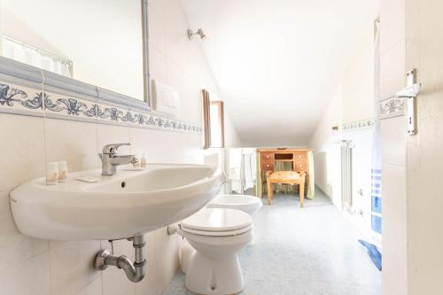 a white bathroom with a sink and a toilet at Faustina - Agriturismo La Valentina in Talamone