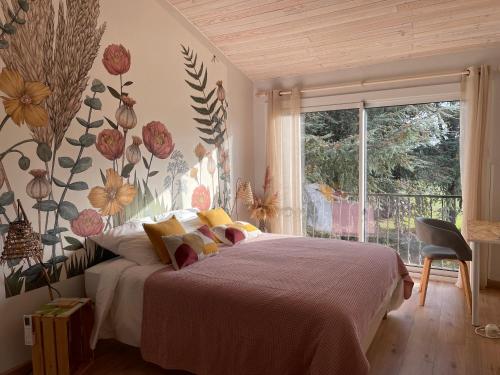 Les Hauts de Beillard في Merville: غرفة نوم مع سرير مع زهور على الحائط