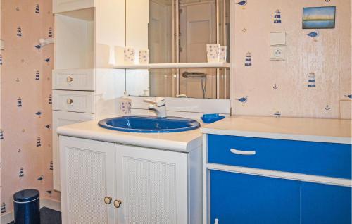 La salle de bains est pourvue d'un lavabo bleu et d'un miroir. dans l'établissement 4 Bedroom Lovely Home In Langueux, à Langueux