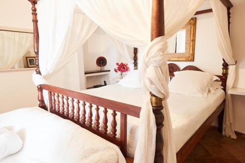 two beds in a bedroom with a canopy bed at Viewstar in Gustavia