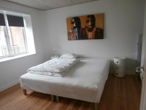 a white bed in a room with a painting on the wall at Rolfsgade 105 st th (id197) in Esbjerg