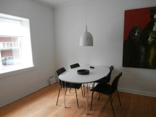 a dining room with a white table and chairs at Rolfsgade 105 st th (id197) in Esbjerg