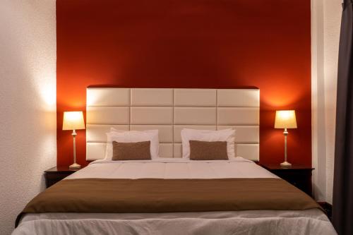 a bedroom with a large white bed with two lamps at Royal Breeze Paramaribo in Paramaribo