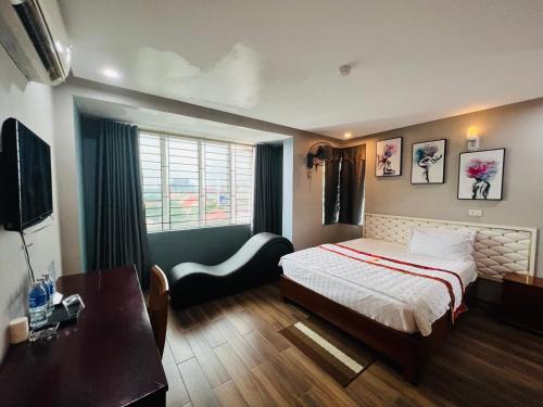 a bedroom with a bed and a table and a desk at Hoang Ngan 1 Hotel - TP. Vinh in Vinh
