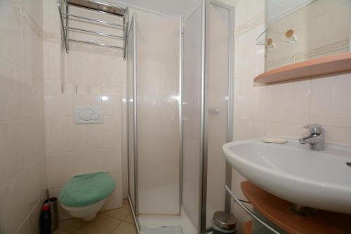 uma casa de banho com um chuveiro, um lavatório e um WC. em Gaestehaus-Flandern-5 em Borkum