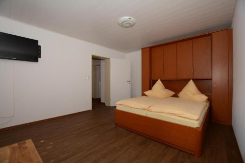 Schlafzimmer mit einem Bett und einem Flachbild-TV in der Unterkunft "Gästehaus Flandern" 5 in Borkum