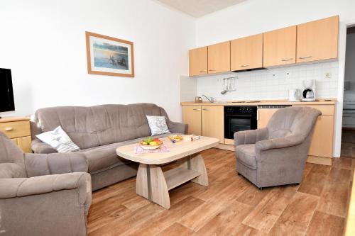 ein Wohnzimmer mit einem Sofa, einem Tisch und Stühlen in der Unterkunft Haus Herrmann 2 in Borkum