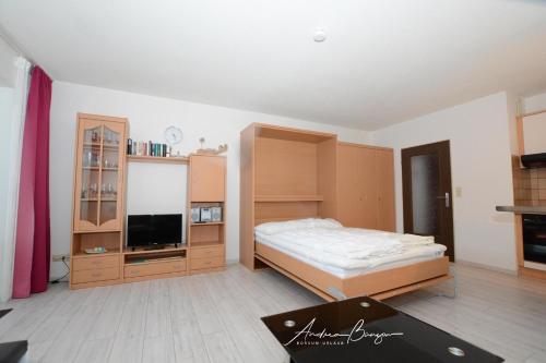 een slaapkamer met een bed en een flatscreen-tv bij Krabbe in Borkum