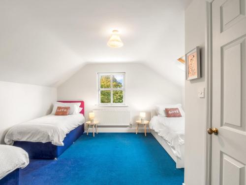 a room with two beds and a window at Sycamore Cottage in Clifden