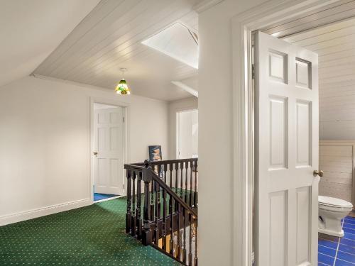 a bathroom with a staircase and a toilet at Sycamore Cottage in Clifden