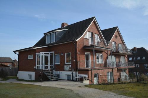 a large brick house with a balcony on the side at Haus-Koenigsduene-II-5 in Borkum