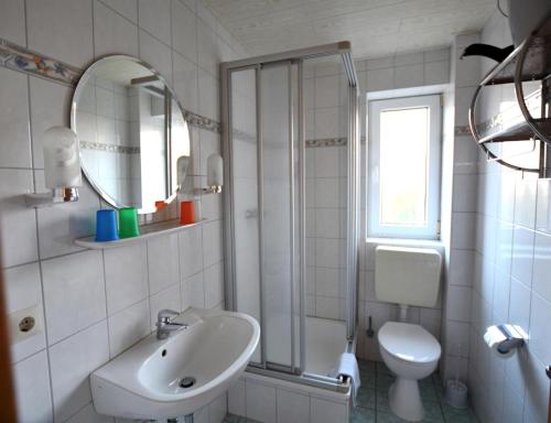 a bathroom with a sink and a toilet and a mirror at Haus-Koenigsduene-II-5 in Borkum