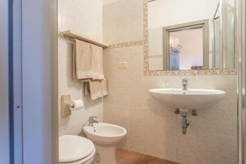 a bathroom with a sink and a toilet and a mirror at Gelsomina- Agriturismo La Valentina in Talamone
