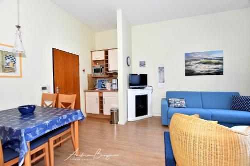 a living room with a blue couch and a table at Nordseehus-Whg-2 in Borkum