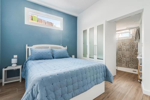 1 dormitorio con paredes azules y 1 cama con edredón azul en Home2Book El Perenquén San Nicolás 1, en Las Palmas de Gran Canaria