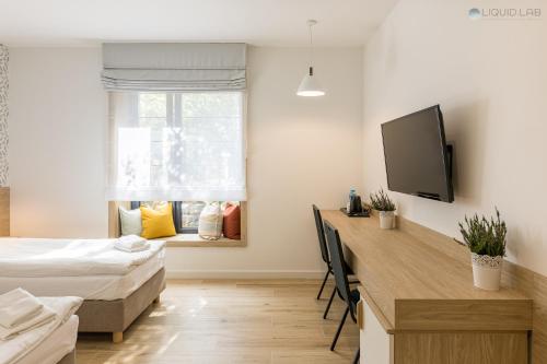 a bedroom with a bed and a desk and a tv at Ośrodek Turystyczny Warzenko in Warzenko