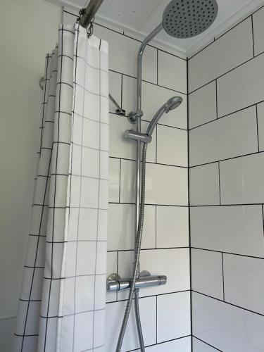 a shower with a shower head in a bathroom at Sea Song Cottage in Broadstairs