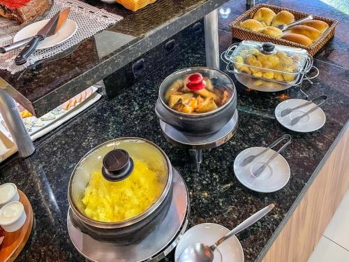 a kitchen counter with several pots and pans of food at Hotel & Pousada Sonho Meu in Florianópolis