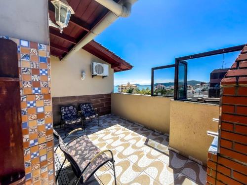 a balcony with a table and chairs and a view at Hotel & Pousada Sonho Meu in Florianópolis