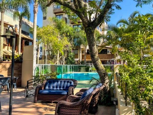 un complejo con piscina y palmeras en Hotel & Pousada Sonho Meu, en Florianópolis