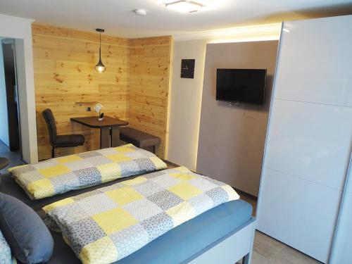 バート・ビルンバッハにあるFerienwohnung & App. Rosemarieのベッドルーム1室(ベッド1台、テーブル、テレビ付)