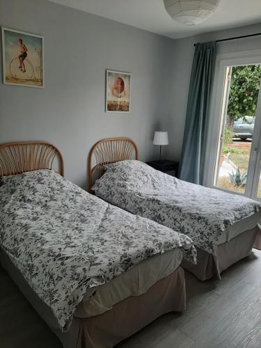 dos camas sentadas una al lado de la otra en un dormitorio en Maison Bleue, en Montagne