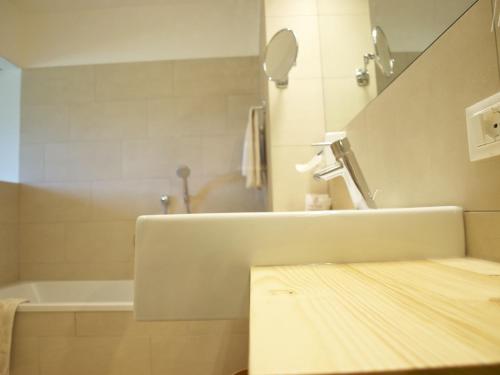 a bathroom with a sink and a bath tub at Hotel Tyrol in Funes