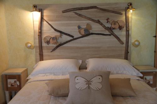 a bed with a wooden headboard with a butterfly on it at Luxury villa Colle dell'Asinello ,proprietari ,Villa In esclusiva near ORVIETO in Guardea