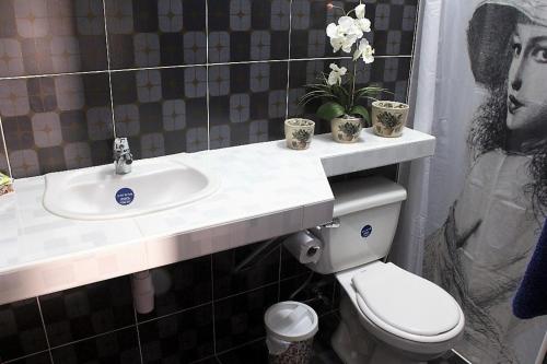 a bathroom with a toilet and a sink with a picture of a man at Casa Gran Cañn Appartement 1 in Playa Larga