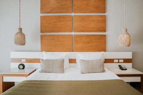 a bedroom with a white bed with two pillows at The Reef 28 Hotel & Spa - Luxury Adults Only - All Suites - With Optional All Inclusive in Playa del Carmen