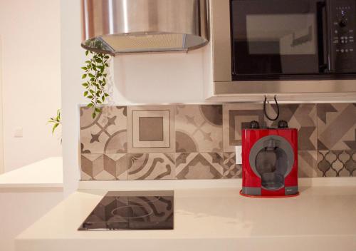 a kitchen with a microwave and a red blender at ISA Cádiz in Cádiz