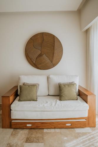 a white couch with two pillows in a room at The Reef 28 Hotel & Spa - Luxury Adults Only - All Suites - With Optional All Inclusive in Playa del Carmen
