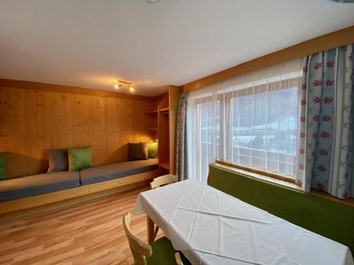 ザンクト・アントン・アム・アールベルクにあるFerienhaus am Eggliのベッド、テーブル、窓が備わる客室です。