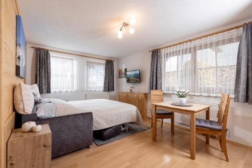 um quarto com uma cama, uma secretária e uma mesa em Appartement Summerer Peter em Mayrhofen